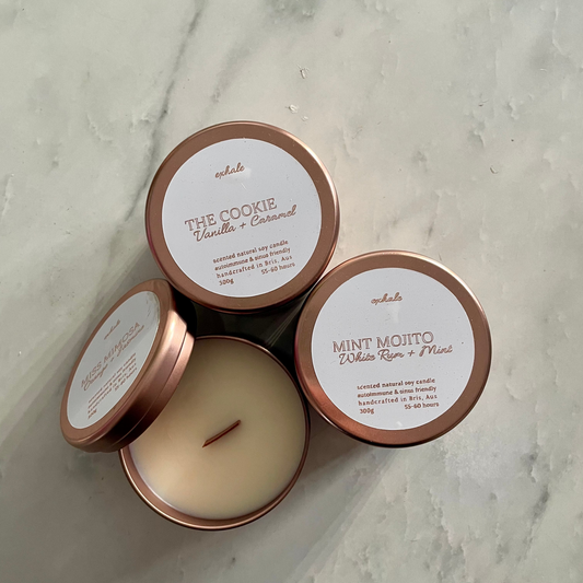 Three candles with lids on a marble surface